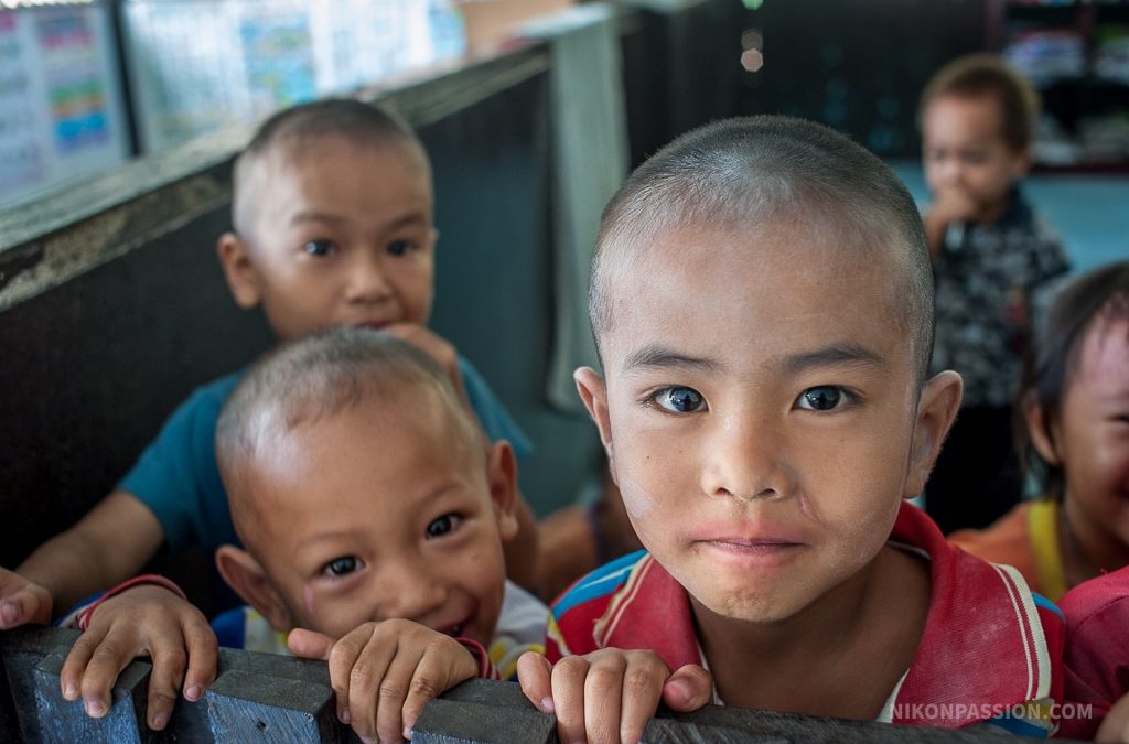 Portrait d’un enfant dans un village thaïlandais, pris au 35 mm en toute spontanéité, à travers une cloison d’école