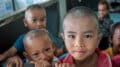 Portrait d’un enfant dans un village thaïlandais, pris au 35 mm en toute spontanéité, à travers une cloison d’école