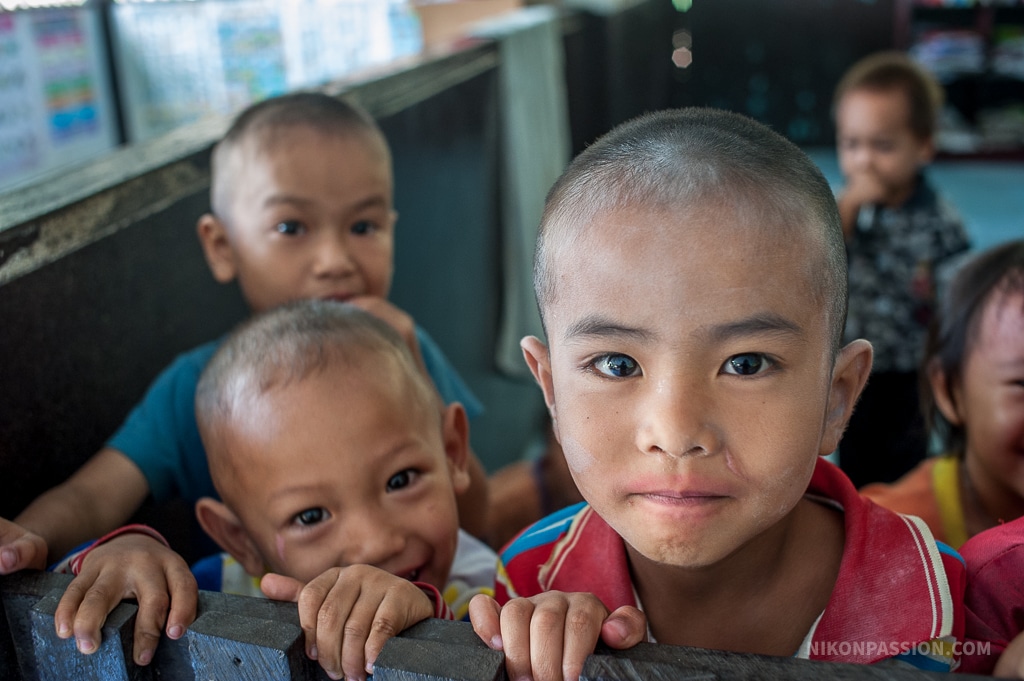Portrait d’un enfant dans un village thaïlandais, pris au 35 mm en toute spontanéité, à travers une cloison d’école