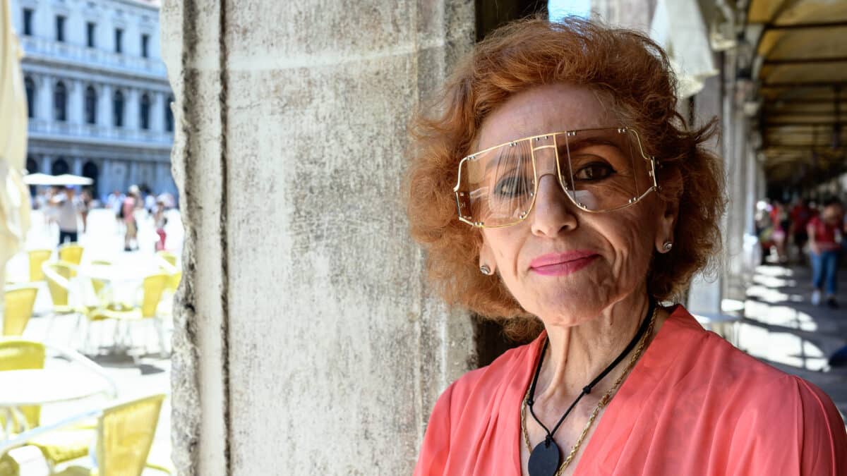 Portrait d'une femme sous les arcades de la place San Marco à Venise, lumière d'été, lunettes de soleil