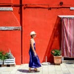 Une femme avec une robe bleue devant un mur rouge à Venise - photo (C) JC Dichant