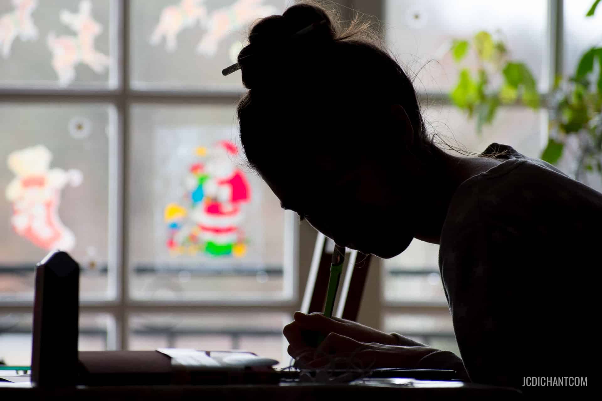 Une jeune femme en silhouette devant une fenêtre colorée - photo (C) JC Dichant