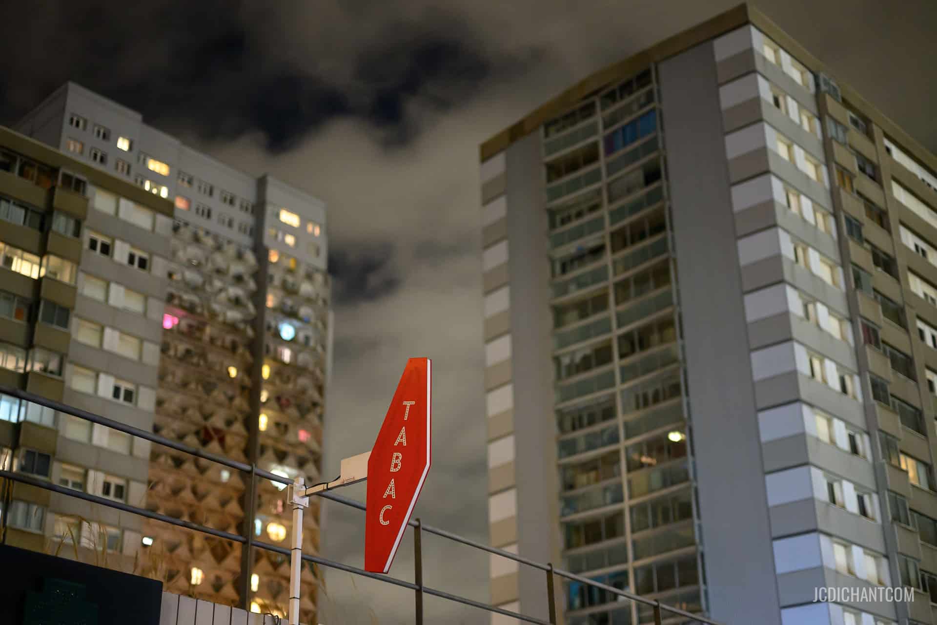 Des immeubles de cité la nuit avec une enseigne Tabac rouge à Vitry-sur-Seine - photo (©) JC Dichant